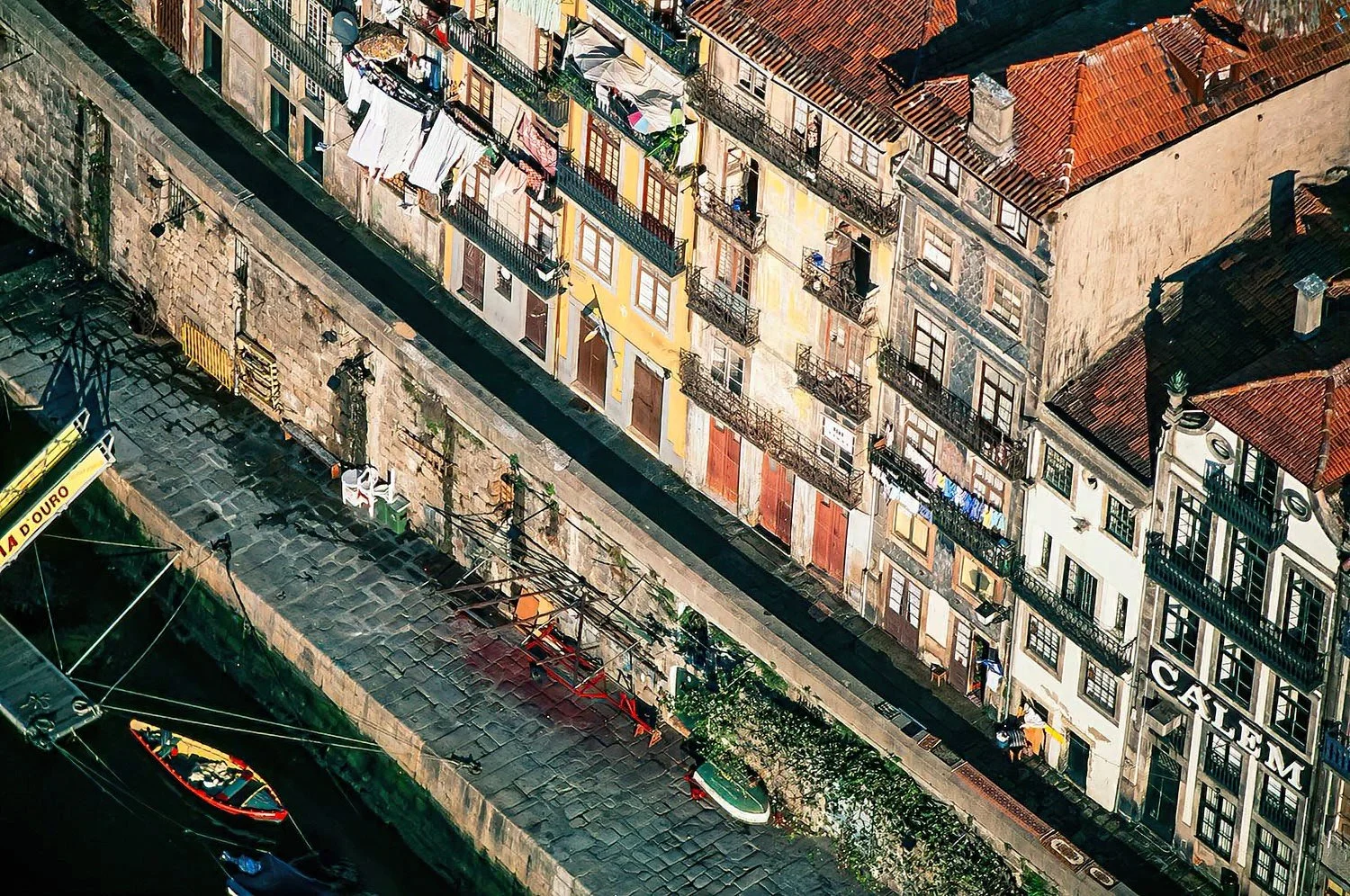 An aerial photo of Porto, Portugal.  The Ribeira district buildings in Porto are colorful, narrow, multi-story houses and shops right along the Douro River, often with wrought-iron balconies.