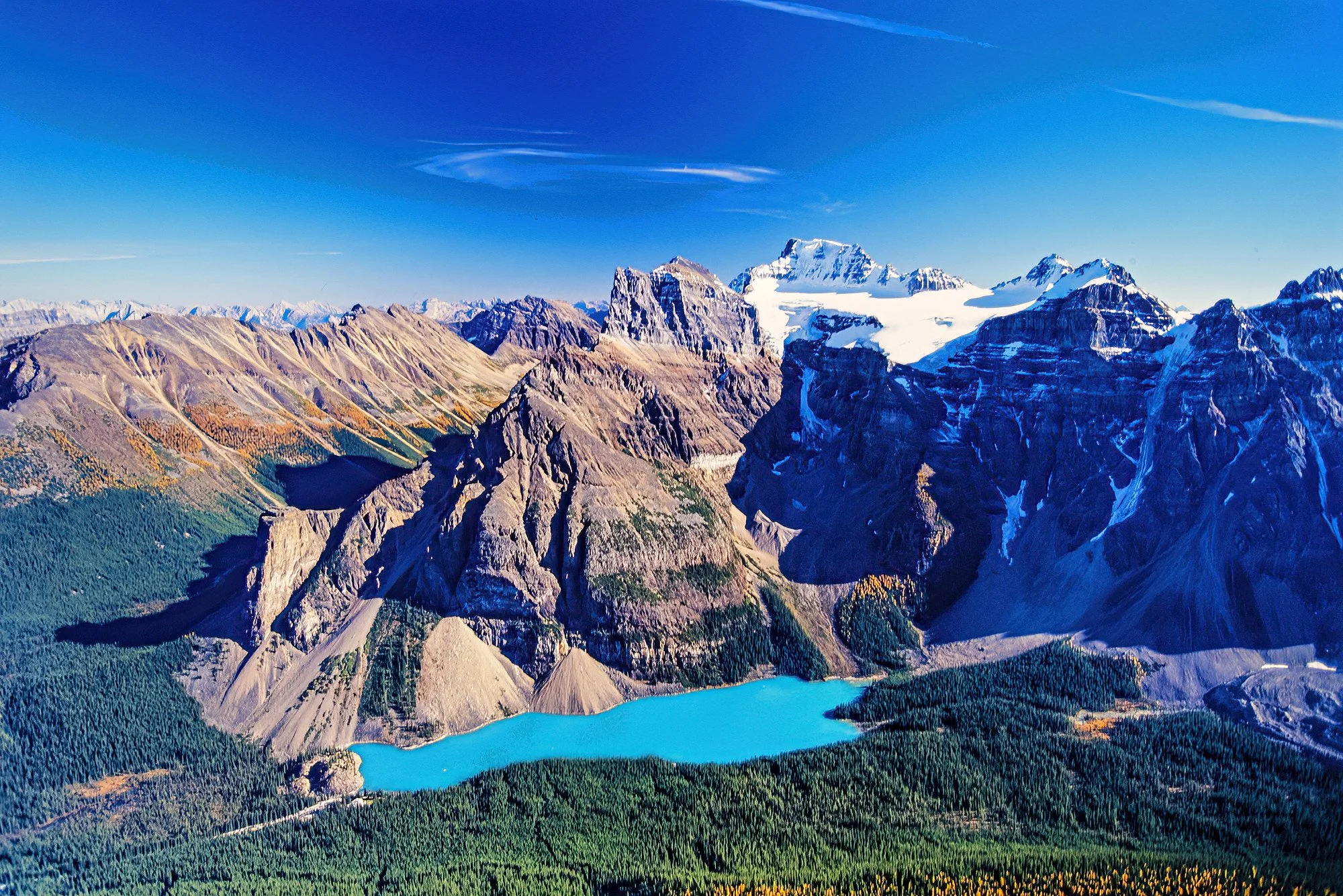An aerial photo of Moraine Lake, Alberta, Canada.  A stunning glacial lake famous for its vivid turquoise waters set beneath the dramatic peaks of the Valley of the Ten Peaks.