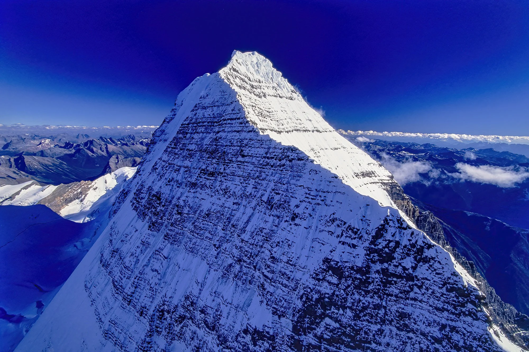 An aerial photo of Mt. Robson, BC, Canada.  It is the tallest peak in the Canadian Rockies at 12,972 feet (3,954 meters) from base to summit and its often cloud-shrouded, imposing presence.