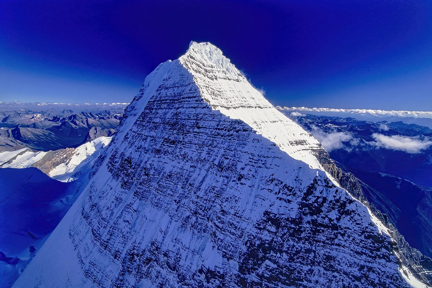An aerial photo of Mt. Robson, BC, Canada.  It is the tallest peak in the Canadian Rockies at 12,972 feet (3,954 meters) from base to summit and its often cloud-shrouded, imposing presence.