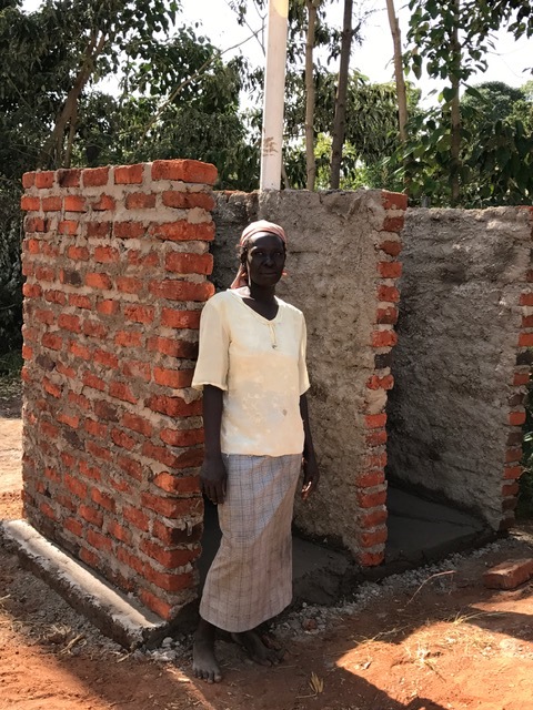 Agness next to her new outhouse and bathing area. All the neighbors have been coming over wondering what is going on. They are amazed that a widow would be helped. It's all because of Jesus Christ!