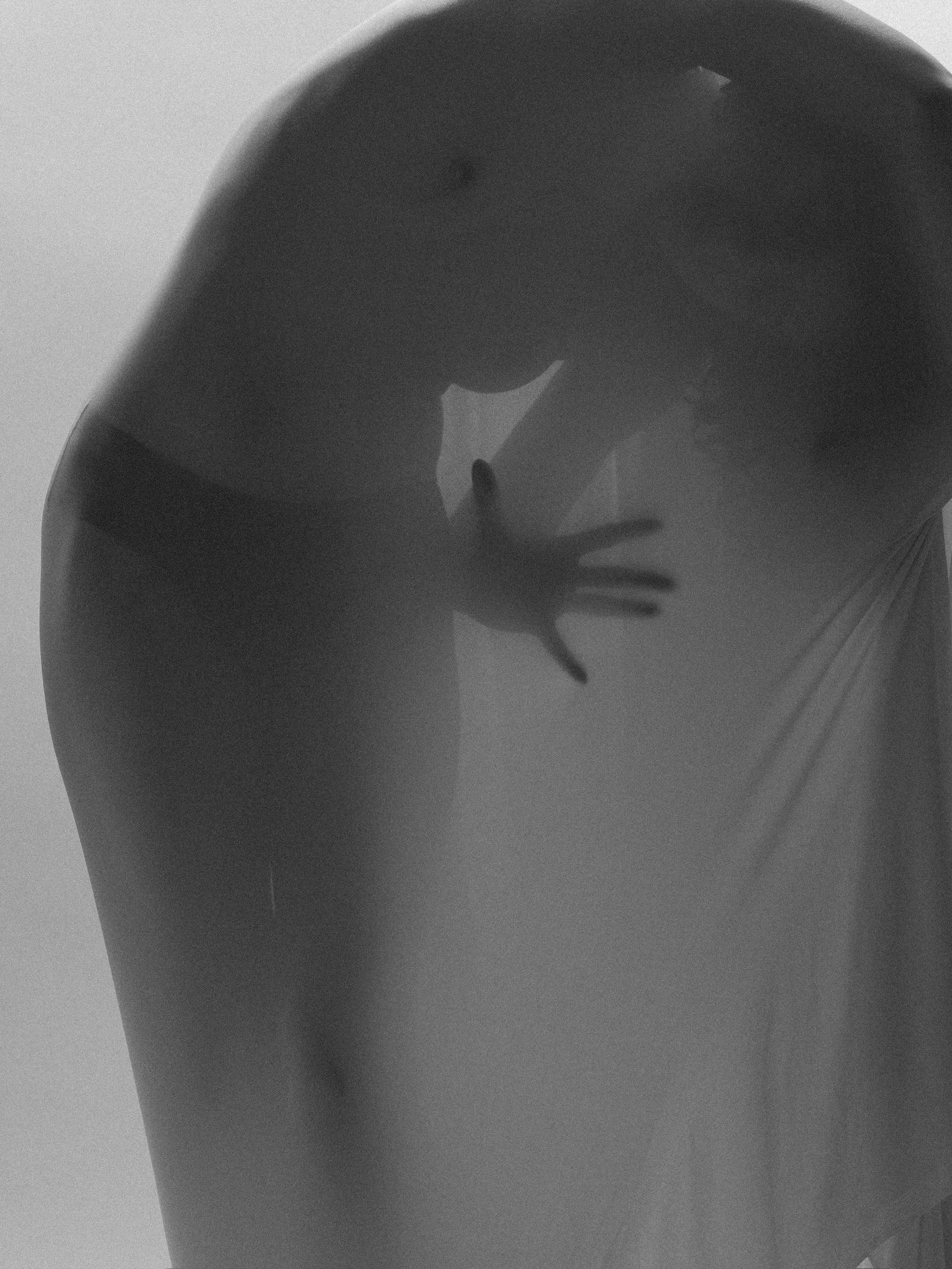 Close-up of a person's midsection, focusing on the back and side. The person is wearing a dark-colored top and appears to be bending forward slightly.