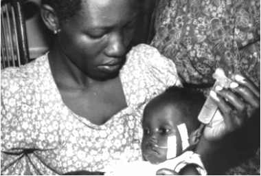 Mother feeding child at the Mwanamugimu Nutrition Rehabilitation Unit, Mulago, Uganda, c. 1965