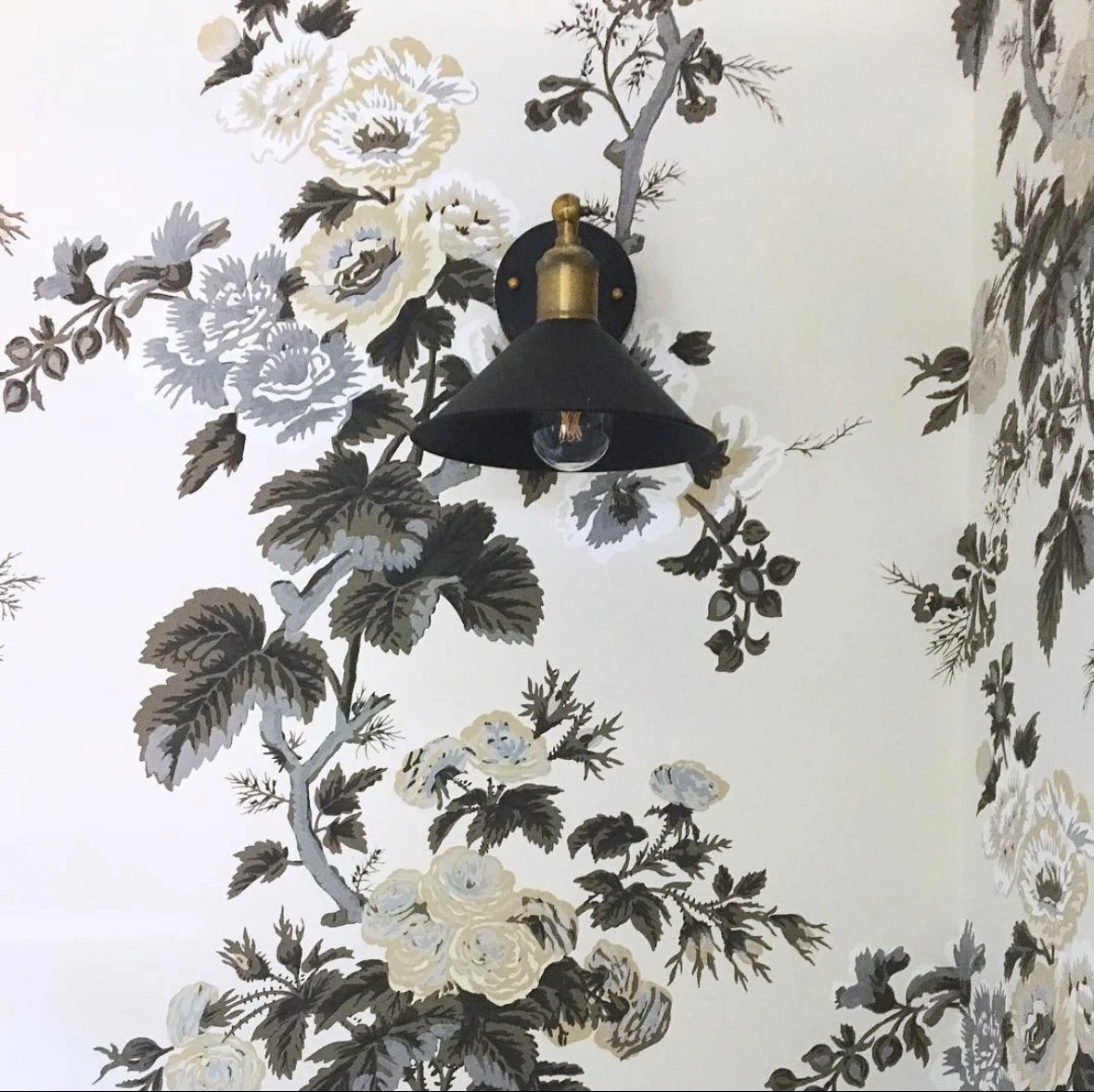 Bathroom interior design featuring Schumacher Hollyhock floral wallpaper with classic, layered detailing.