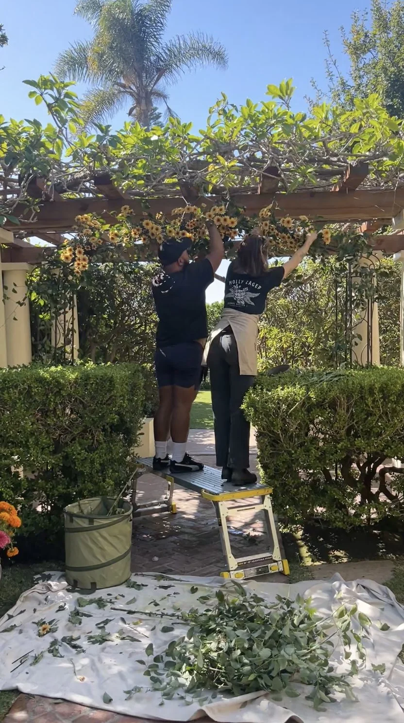 Molly Zager Floral Design team on site at La Jolla Women's Club installing ceremony arch