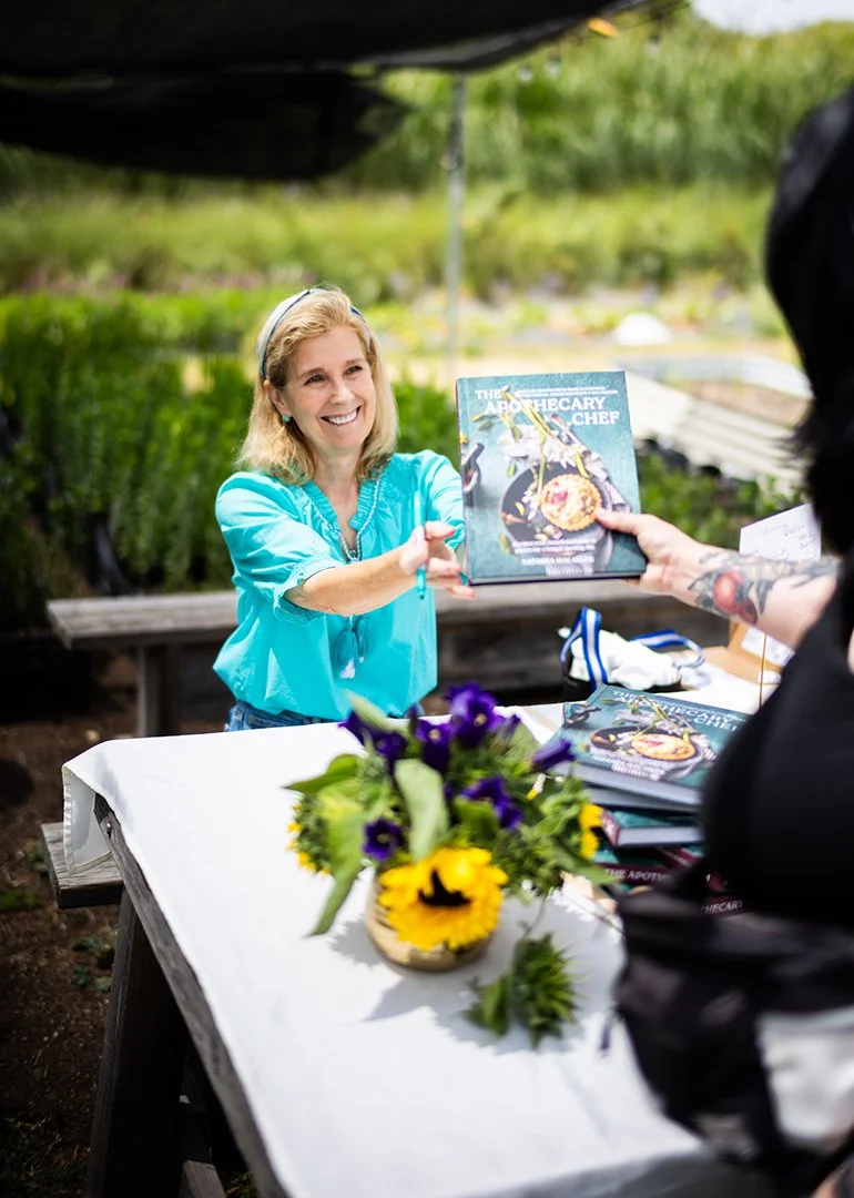 Natasha signing stories and sharing nourishment at Farm Lot 59. • Photos by Lost Traveler Productions | Travis Smith-Evans