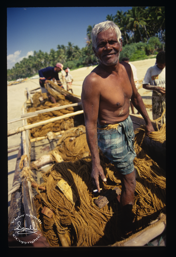 Many moons ago while hitchhiking the southern coast of Sri Lanka with an Australian girlfriend, we came upon these fisherman in Weligama that were preparing their salty old wooden boat for the next catch. I jumped in, leaving Sara safely on shore. There were actually two boys that came on board with the rest of the crew and their sole purpose was to keep bailing water out of boat as the hull continuously leaked throughout the journey. The nets were casted and plentiful fish were caught. I have other black and white images that are being scanned at the moment. More to come. Enjoy.. Taken on Ektachrome 100 iso Slide film.