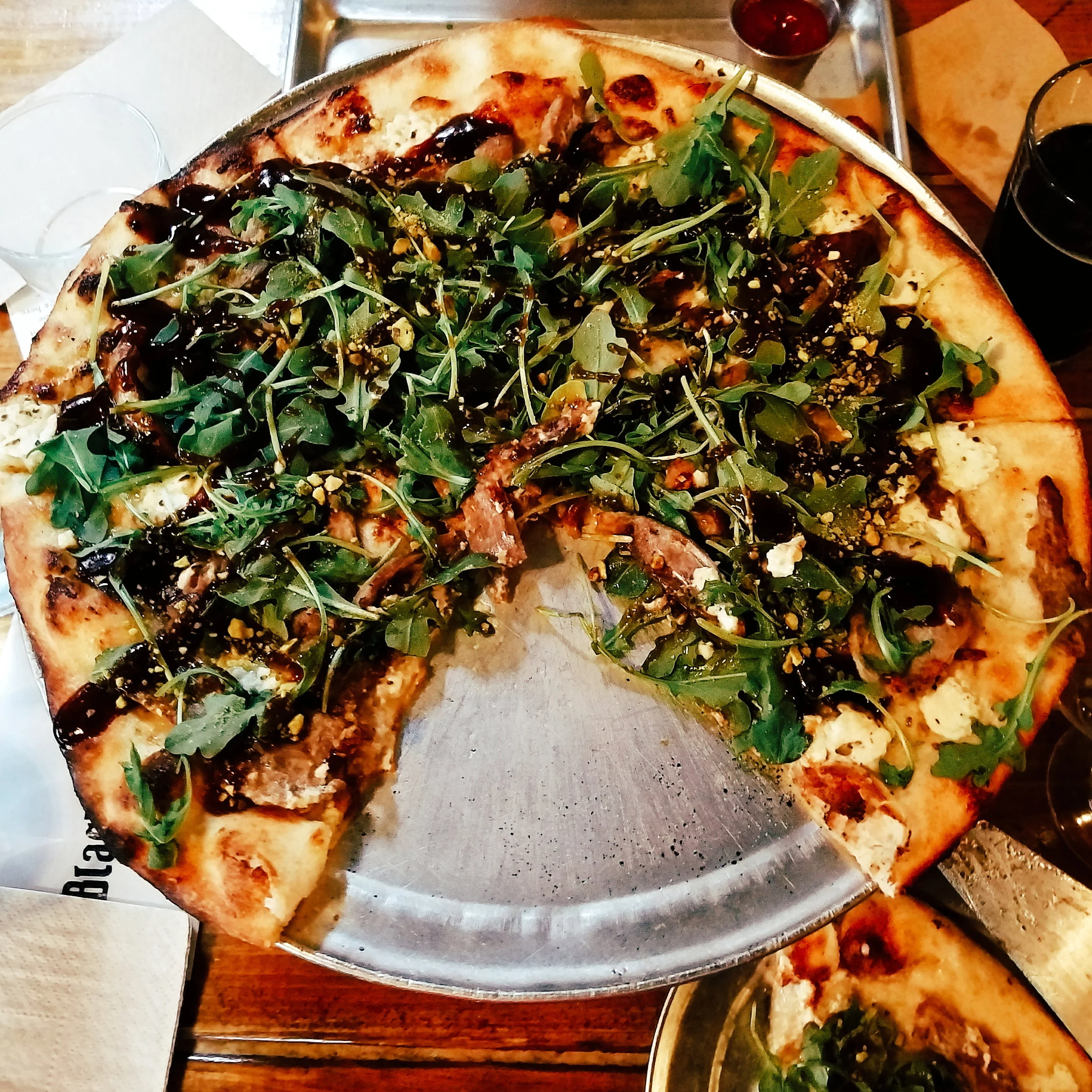 Black Duck Pizza - topped with smoked duck, goat cheese, pistachios, arugula, and a balsamic reduction. Possibly the best pizza I've ever eaten!