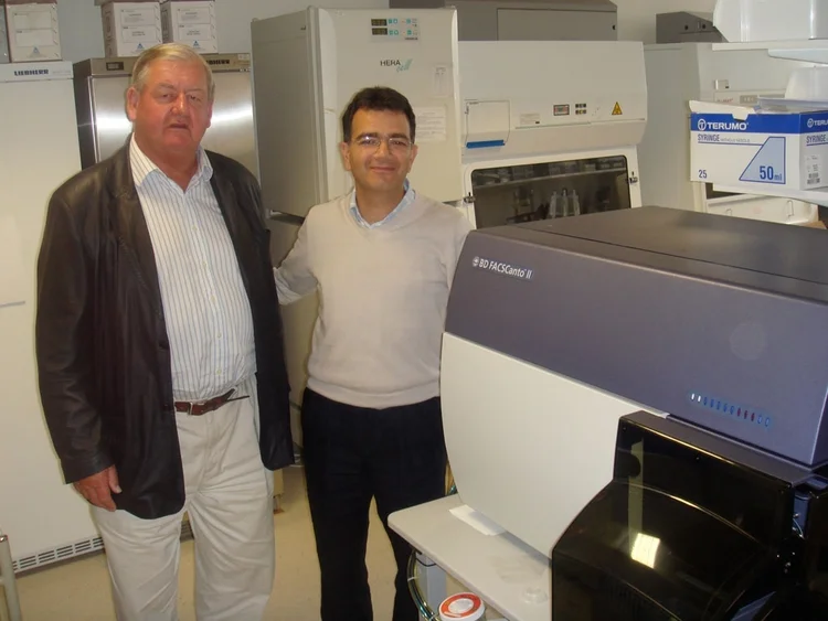 Trustee Donald Legget admires the FACS Canto ii analysis equipment, partly funded by the HMCRT, with Prof. Enzo Cerundolo