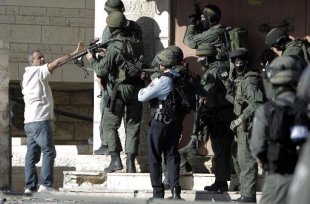 A man holds up his hand as Israeli security and Palestinian stone-throwers clash in the Shuafat neighborhood of Israeli-annexed Arab east Jerusalem, on July 2, 2014, after a Palestinian teenager was kidnapped and killed in an apparent act of revenge.