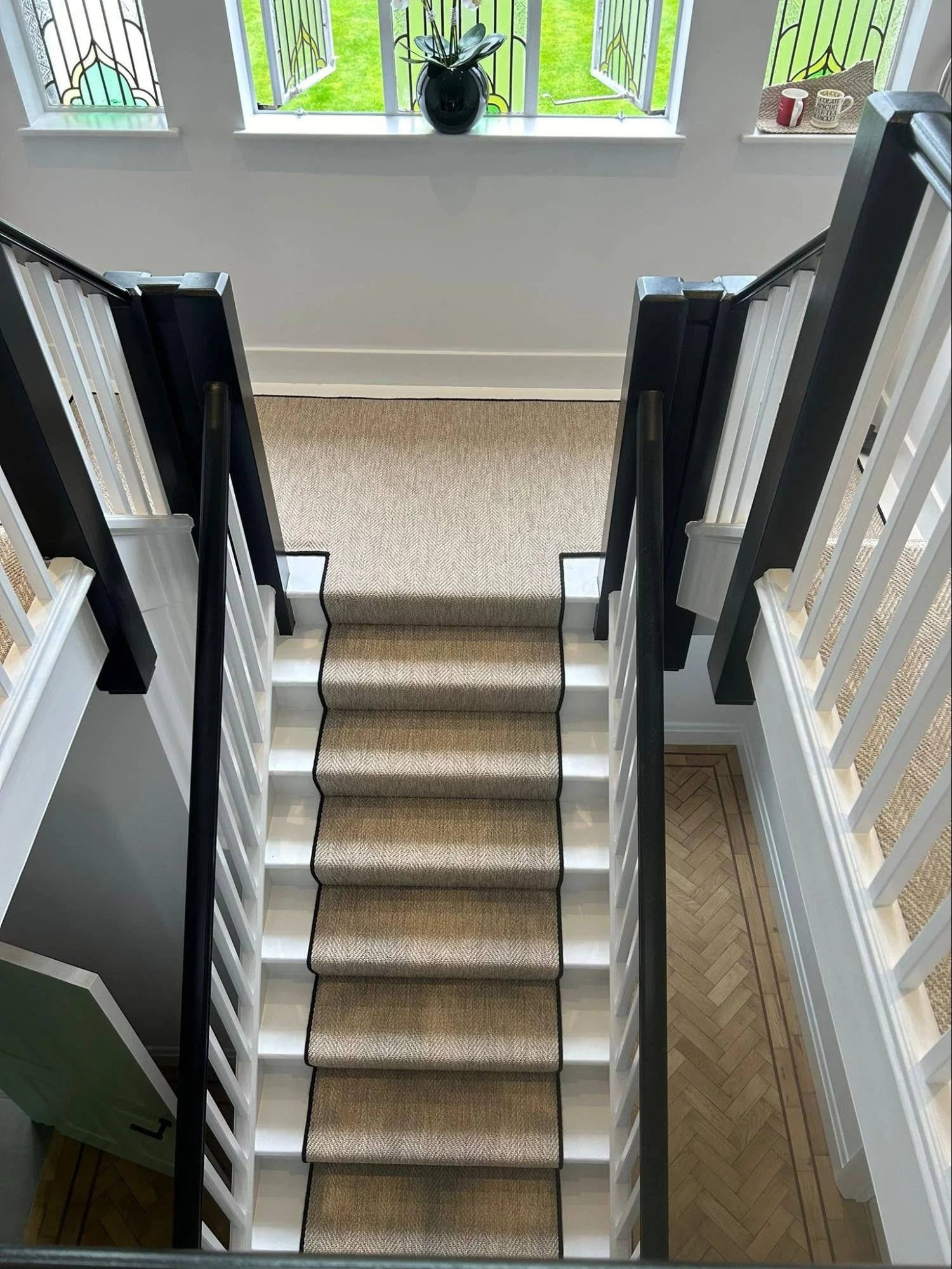 Top-down view of a staircase in a house with beige carpeted steps