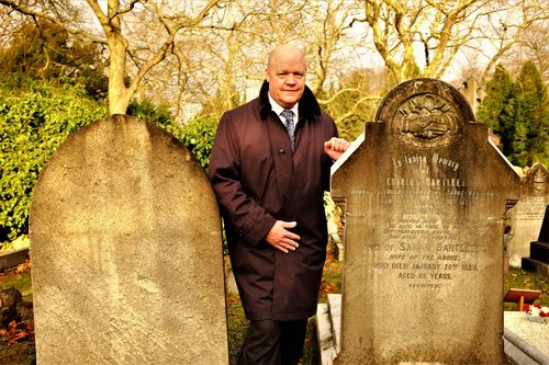 City of London Cemetery and Crematorium Superintendent Gary Burks stands between two graves—one original, one reused.