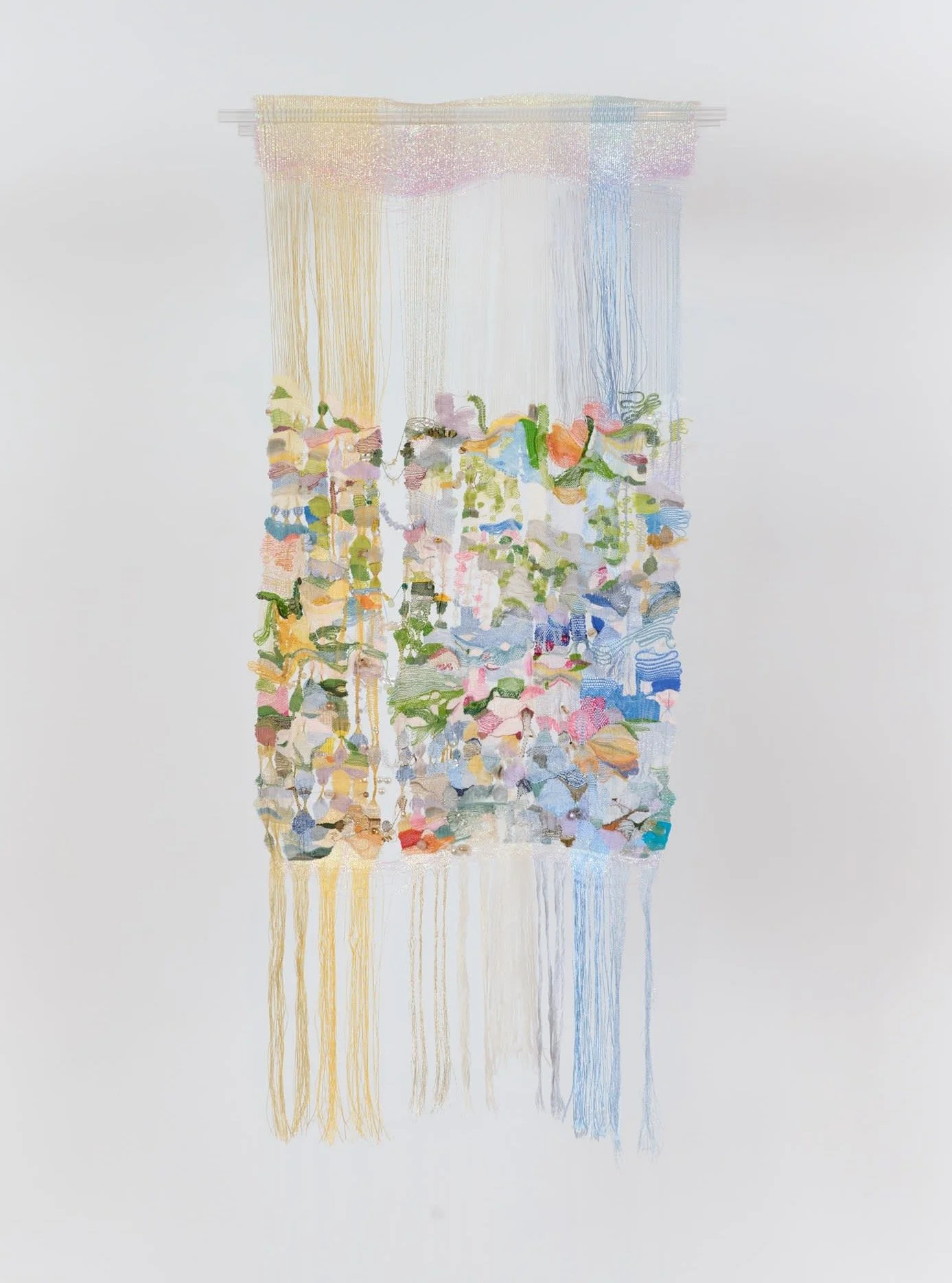 Now showing at Chart in NY, the delicate painted weavings of Jacqueline Qiu seem to conjure form from thin air. In Transient, 2022, vertical threads of pastel yellow, cream and blue support a mass of woven floral abstractions. Symbolic of the passage