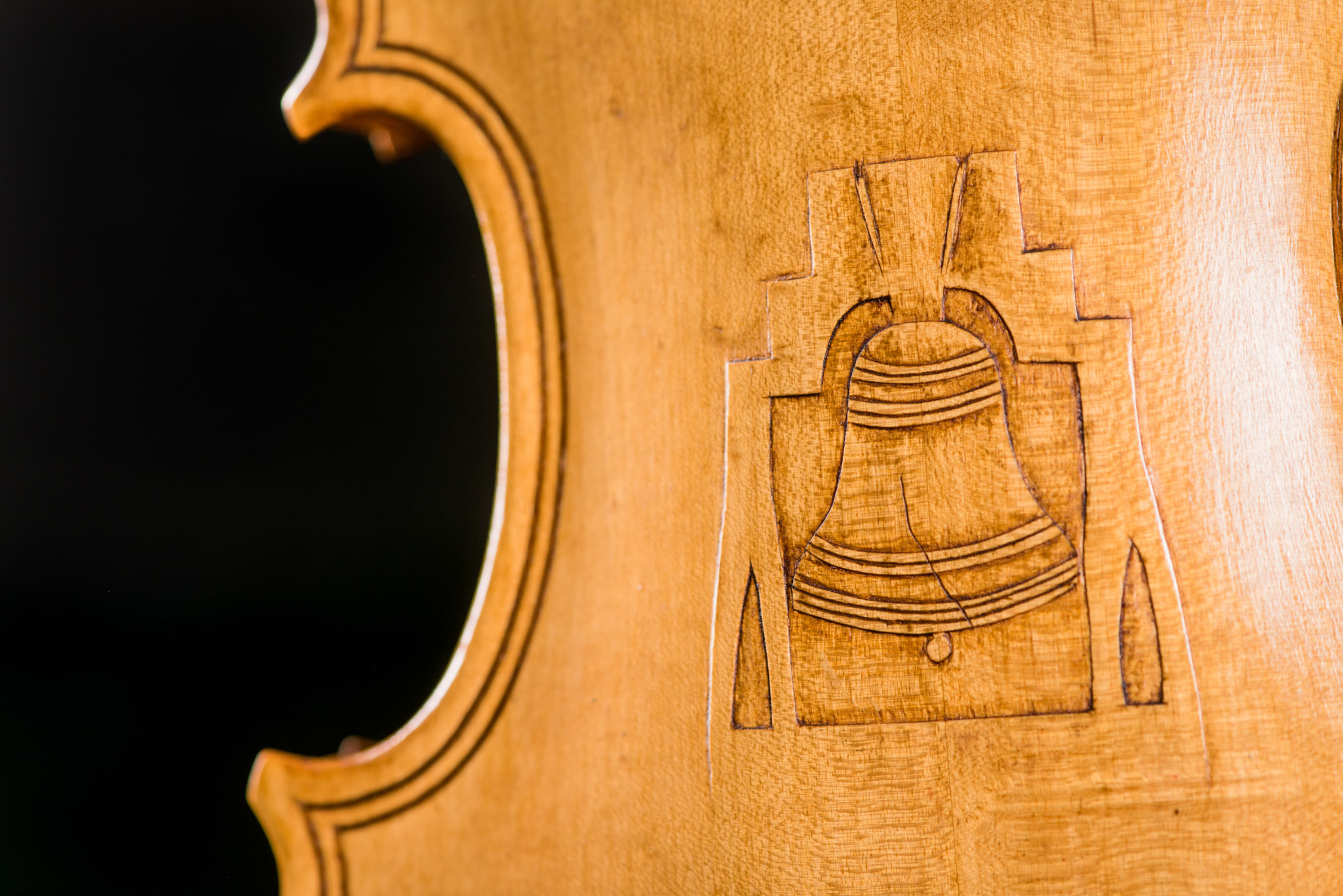 A fiddle carved by Denton Boze with a pocket knife and adorned with an image of the Liberty Bell on the back.