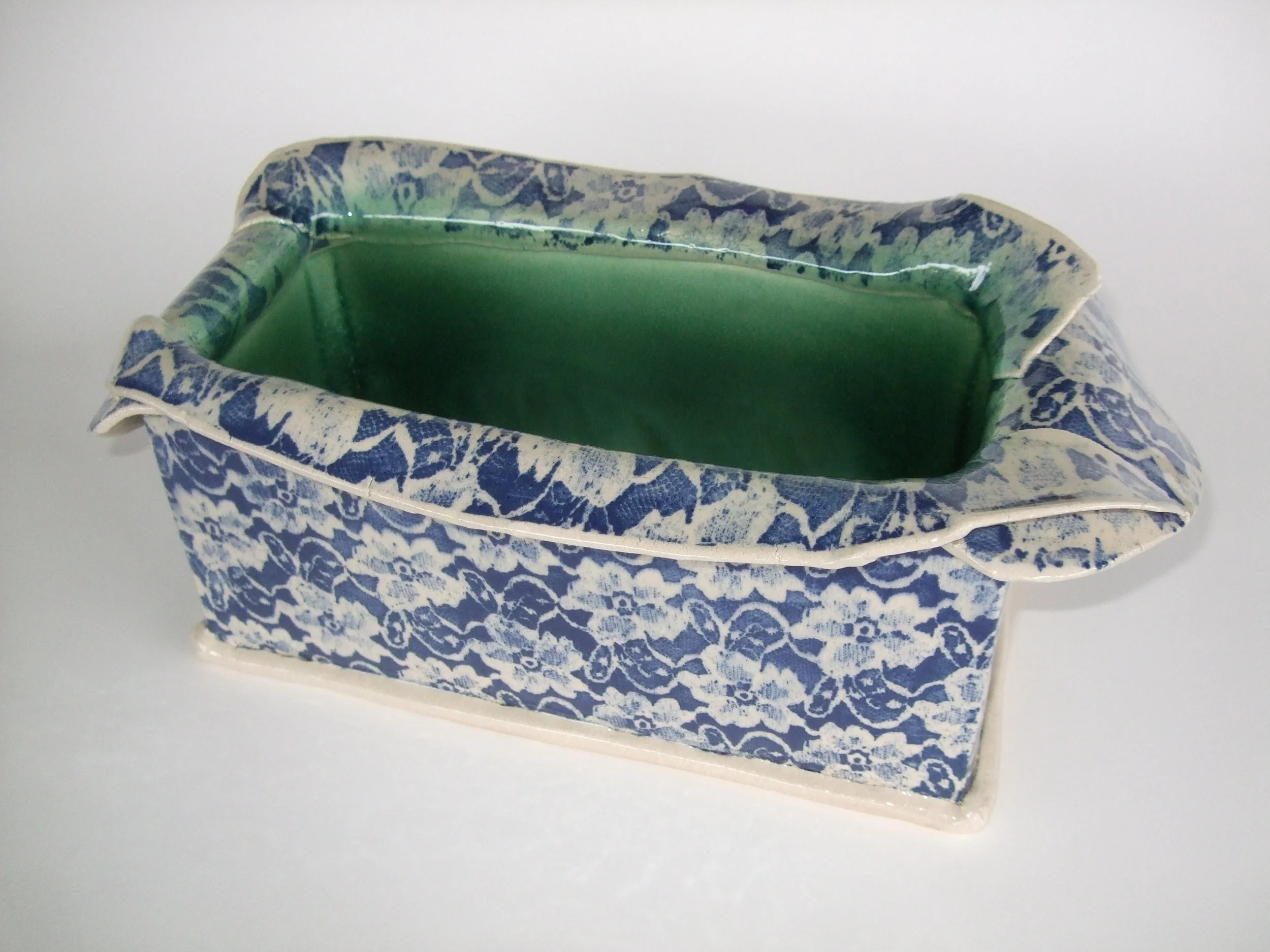  A Planter ready for indoor or outdoor use. The blue floral print, repeated but in a stretched form on the floating rim, contrasts well with the green interior. 
