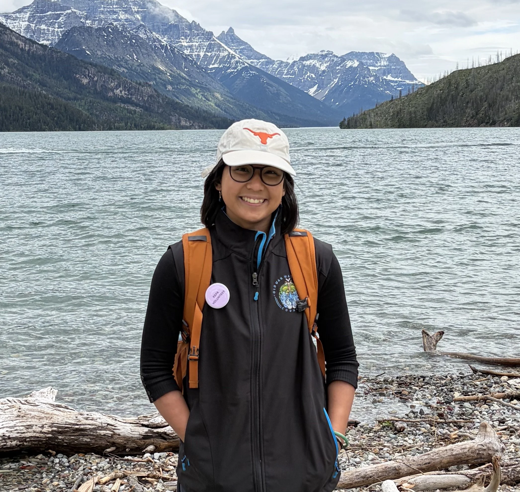 Megan Ramos standing in front of a mountain lake