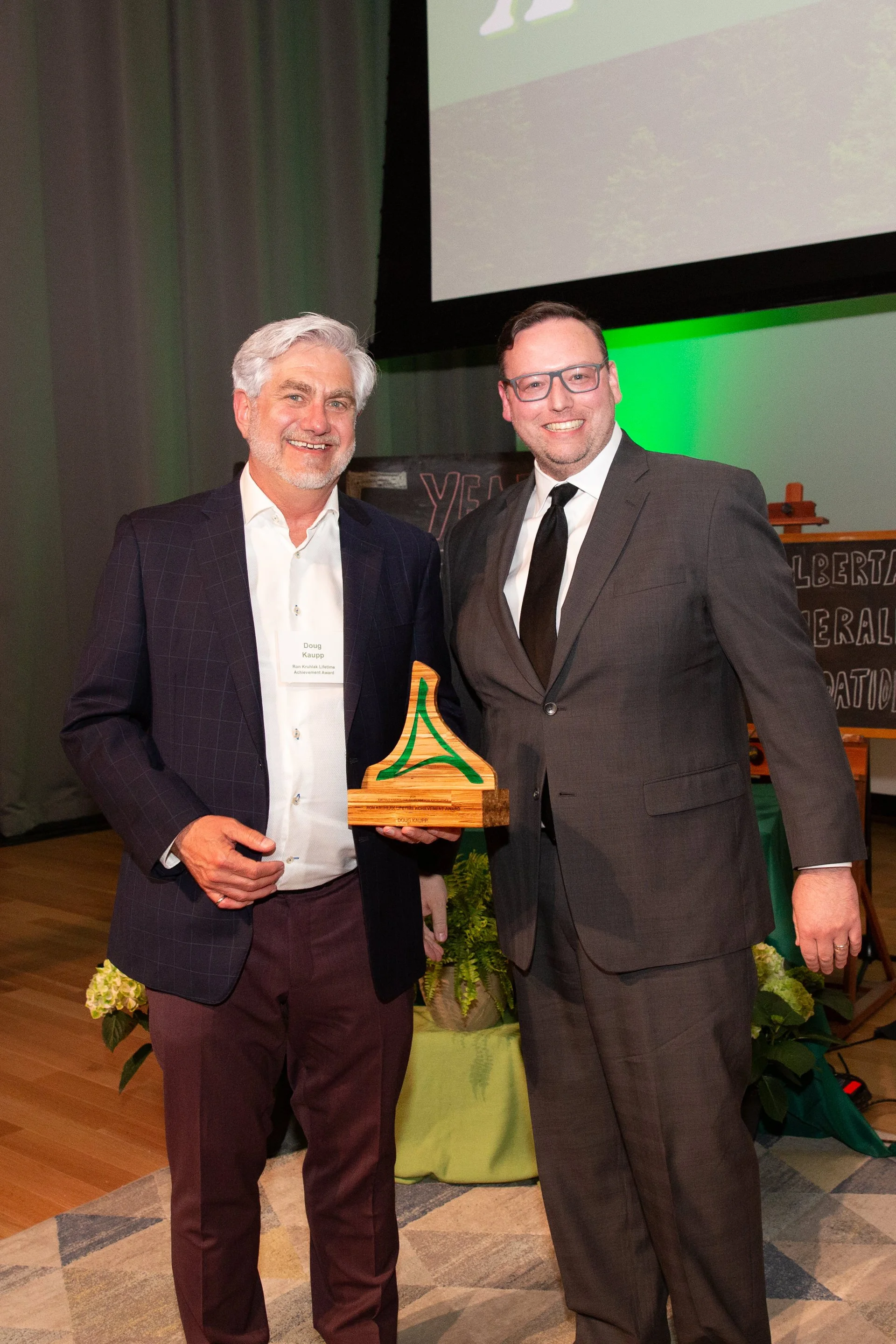 two men wearing suits at an awards gala