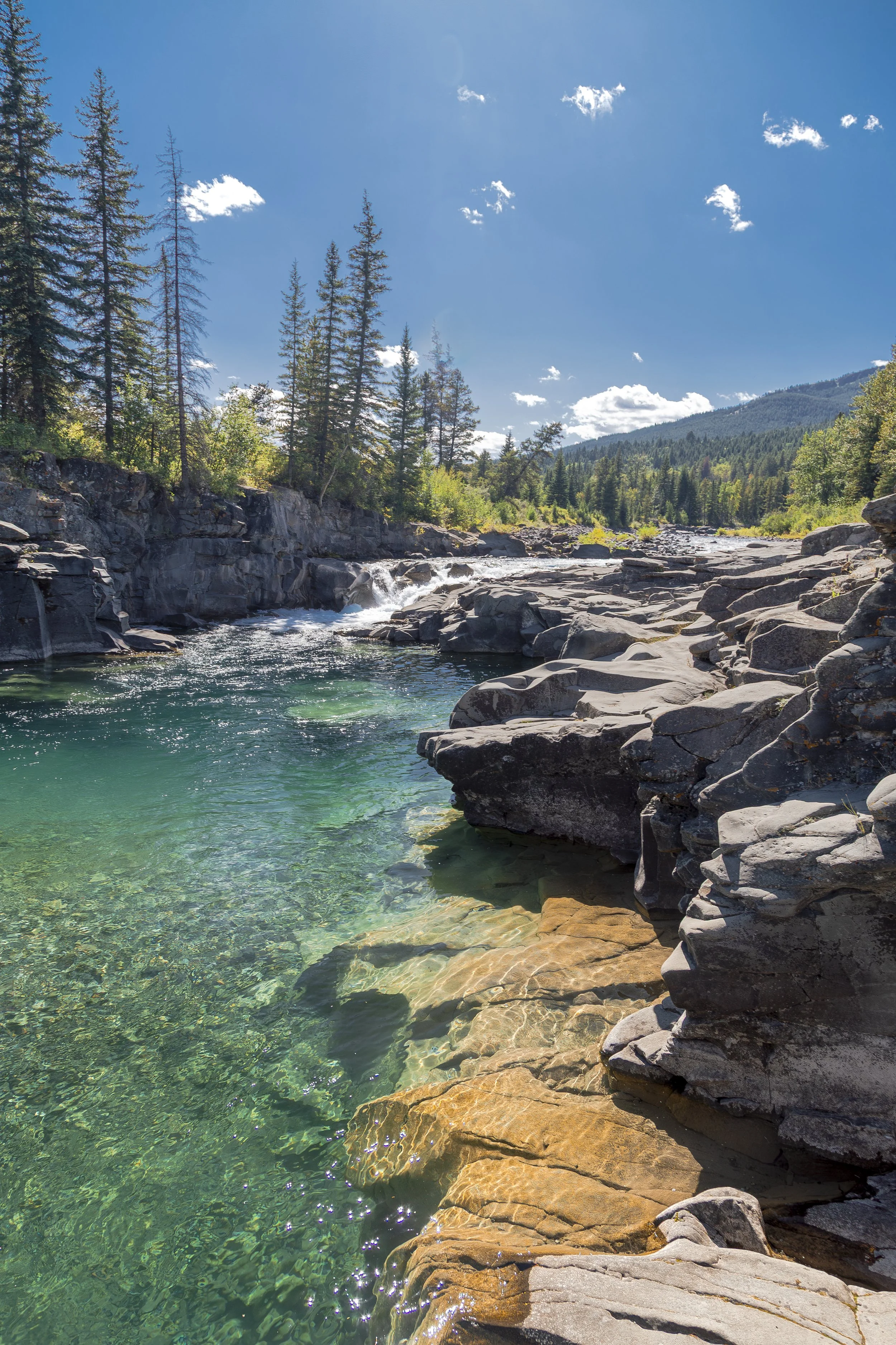 a blue-green river with mountains in the background