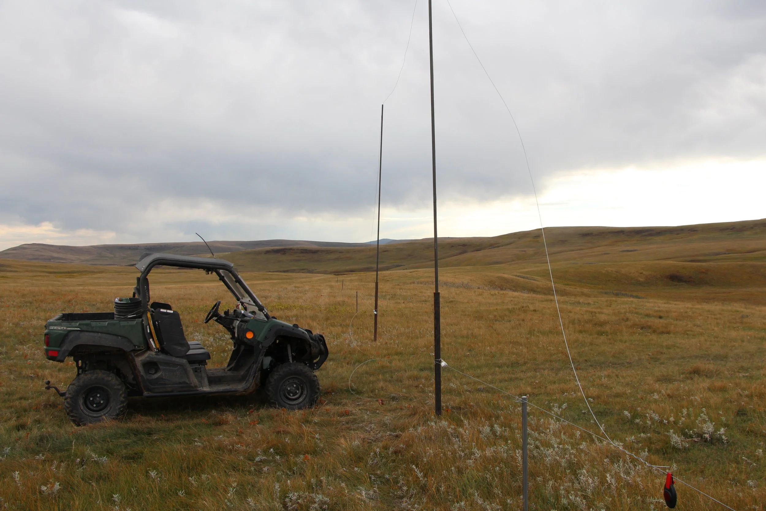 a side-by-side near an electric fence in a field