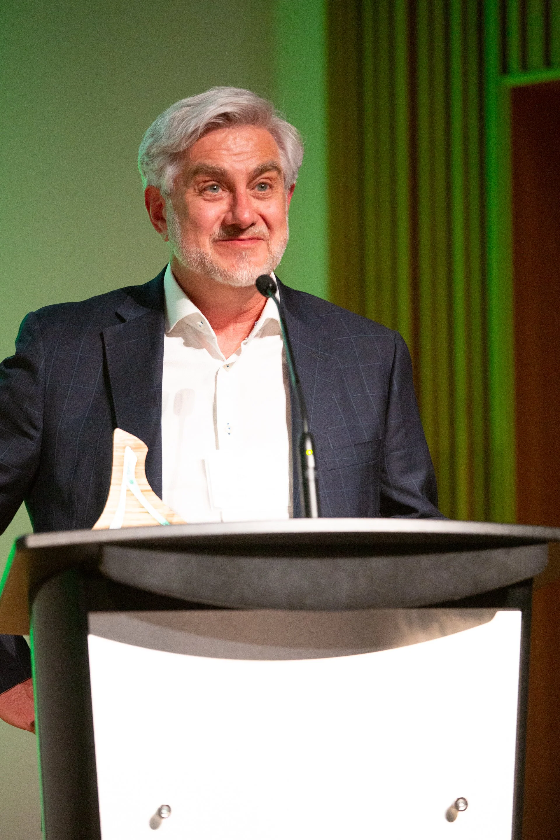 Doug Kaupp standing behind a lectern with a microphone