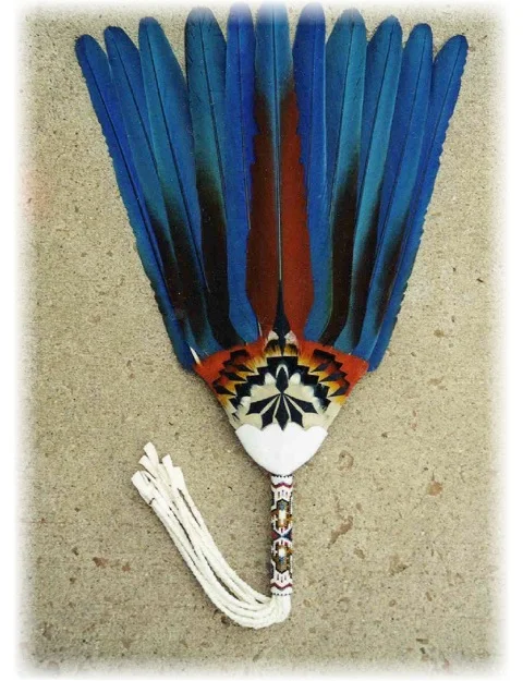 This is a Stiff Flat Fan, GROUPED. These feather are permanently set in place, so the feathers do not move around. The feather work is one whole piece of feather work around the feathers. This fan has a design on the front and the back of the fan. This fan would be use mostly by ladies. It would be use by jingle dress dancers, or used by ladies in the peyote ceremonies. The feather worked is called grouped feather work. This fan is used only for educational purpose.