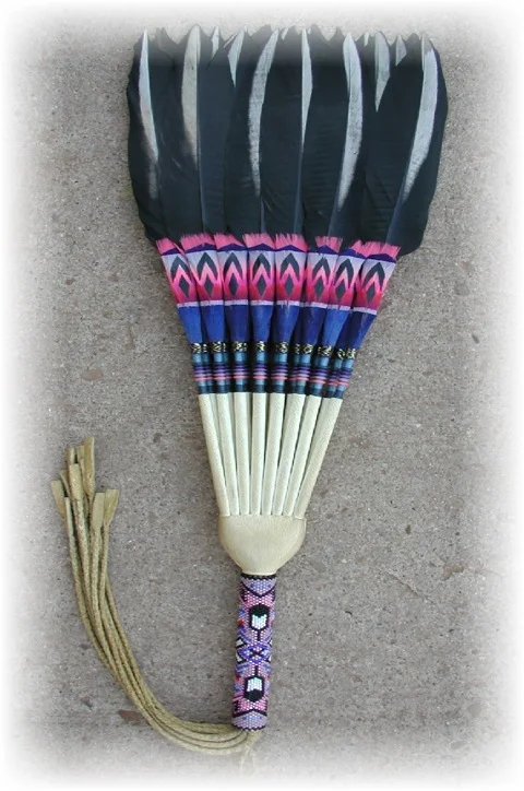 This is a double side, stiff flat fan. This fan has 24 tails in it. It is a double side fan. You can hold the fan any side, and the design is usually the same on both sides of the fan. This type of fan can be made into a side drop fan, by loosing the feathers. It will only open up to the side. For this particular fan, it is a stiff fan. This type of fan is most commonly used in peyote ceremonies and by straight dancers in pow wows.