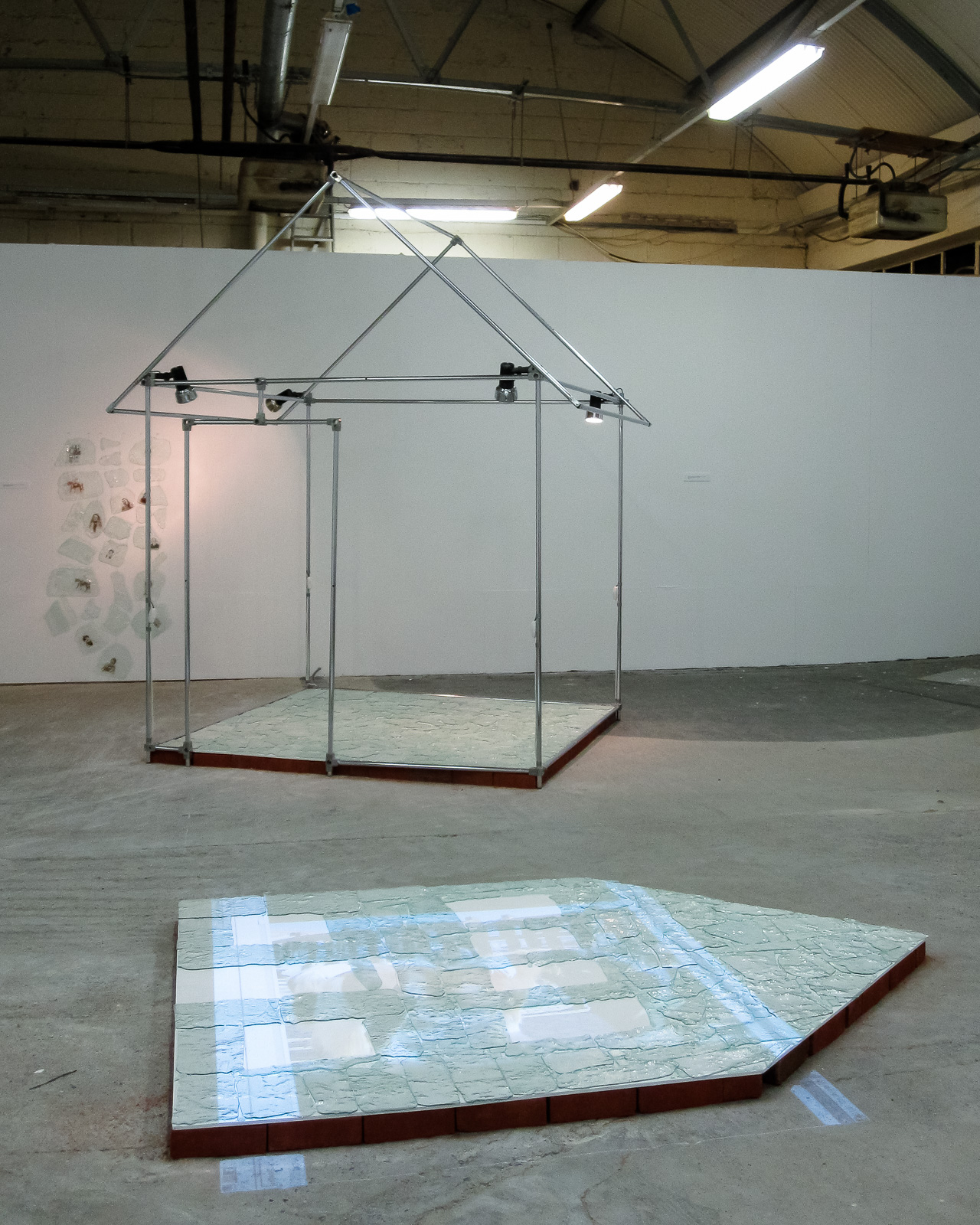  Dwelling on the Celtic Tiger Installation at Irish Museum of Contemporary Art 2010 about the financial crash in Ireland that resulted in many building projects stopped in process. Projected images from ceiling. Recycled window glass, bricks, projector, video,
