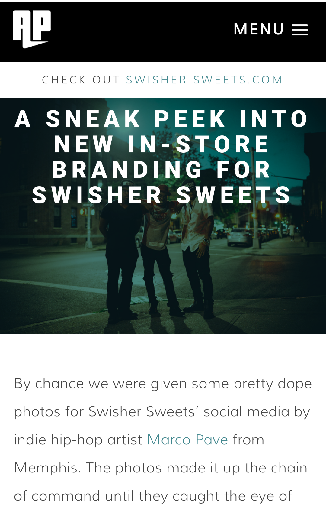 Three men standing on a city street at night with illuminated buildings and cars in the background.