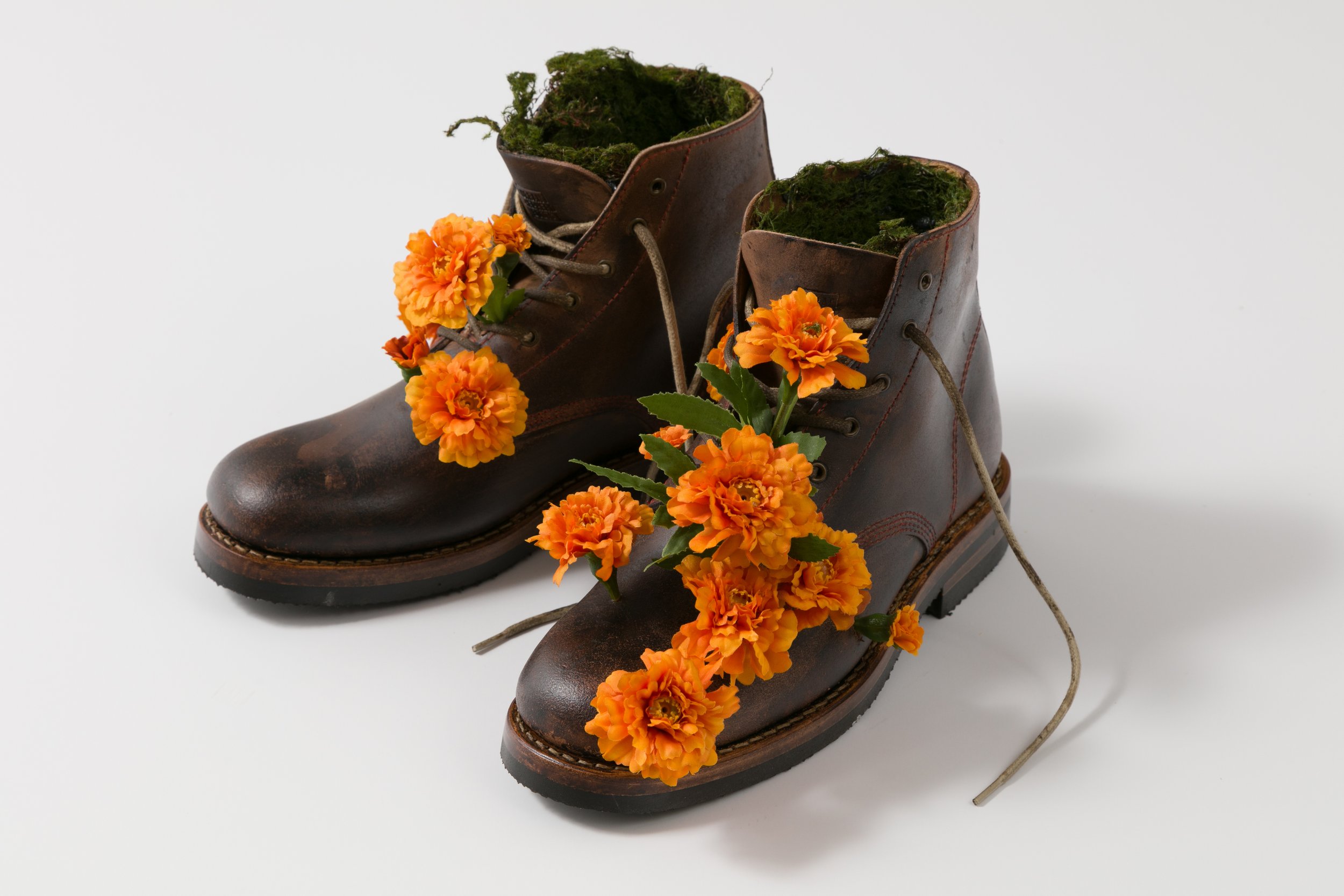 "The Sower", 7"x11"x9", leather boots, artificial flowers, moss, paint