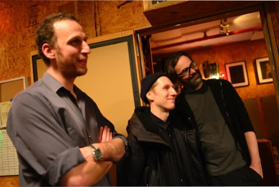 Elan Mehler (L) with mastering engineer Alex Deturk (M) and recording engineer Marc Urselli (R) looking on proudly while the musicians they represent listen on vinyl to their work.