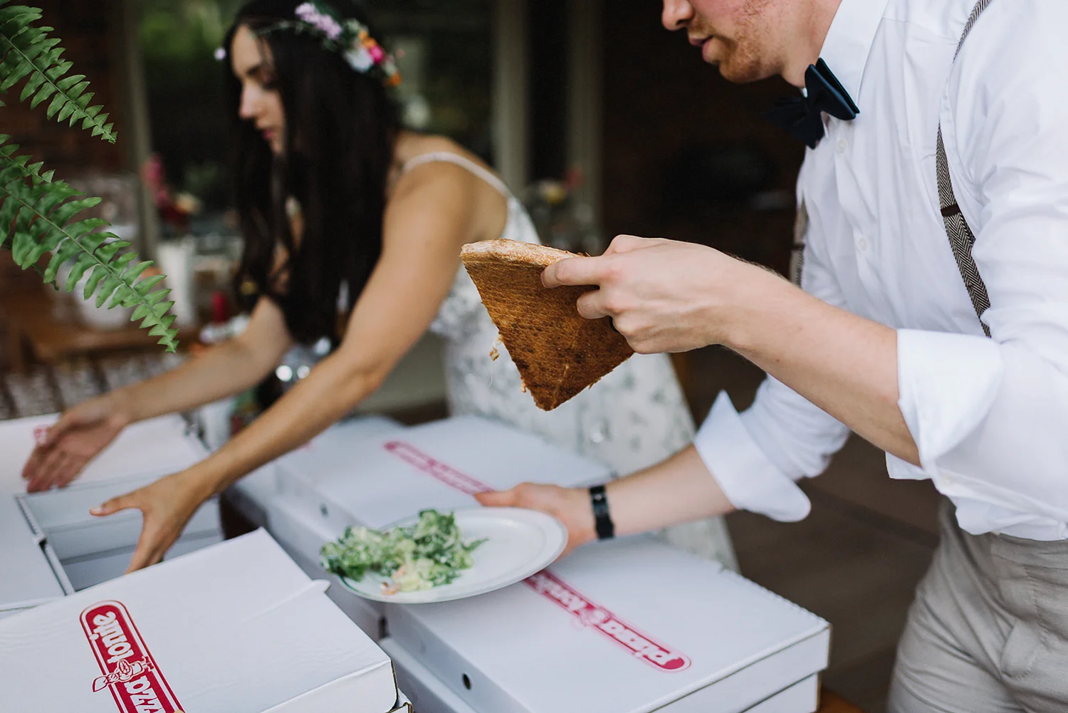 Backyard-toronto-film-photographer-ryanne-hollies-photography-diy-string-lights-and-lanterns-reception-dinner-documentary-wooden-harvest-tables-diy-decor-speeches-bride-and-groom-eating-pizza.jpg