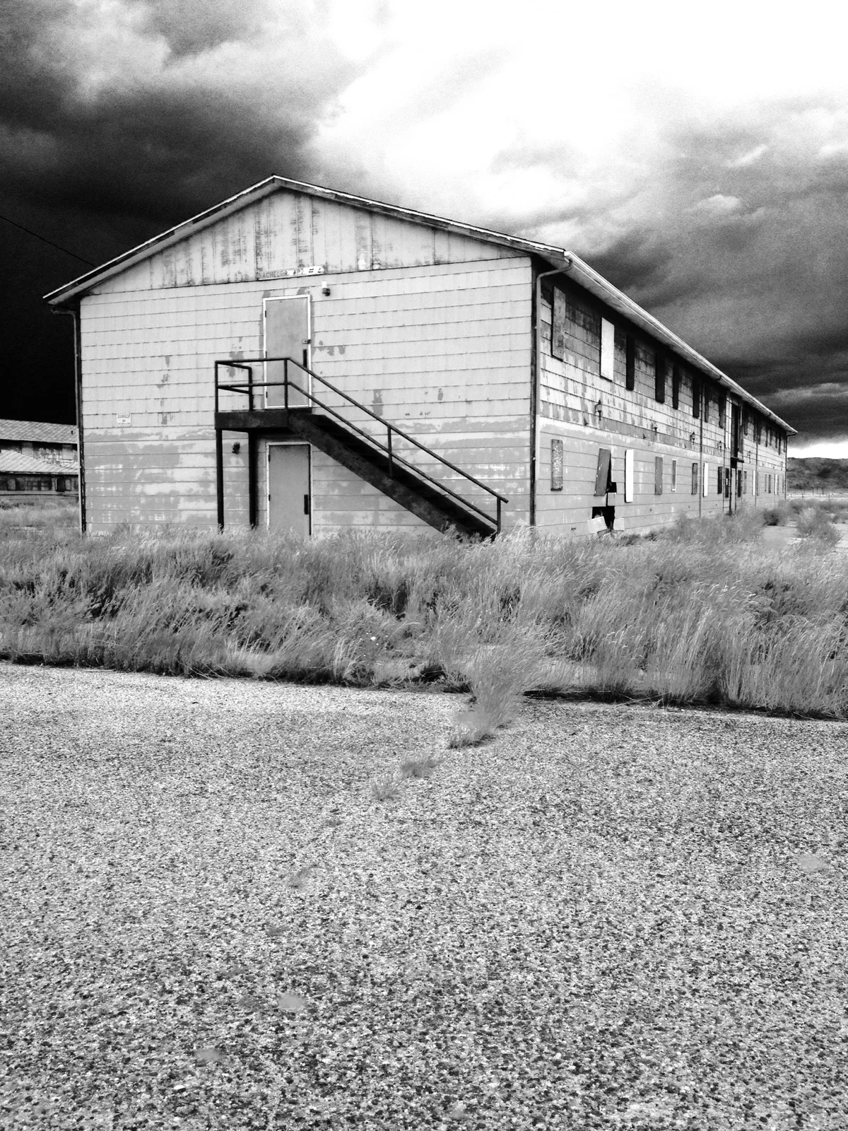An apartment building sits abandoned as a thunderstorm builds on the horizon