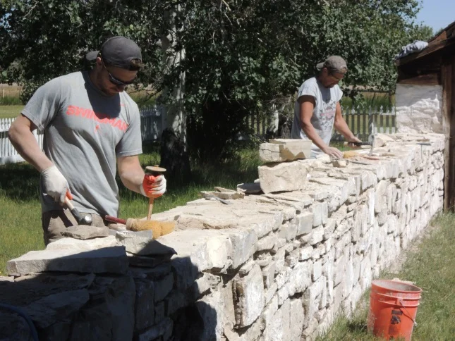 Workers from Wattle and Daub Contractors repair a stone wall at Ft. Bridger in southwestern Wyoming. Several of the stone structures were built by Mormons, who occupied the site before 1860. Historic mortars, which hold the stone structu…