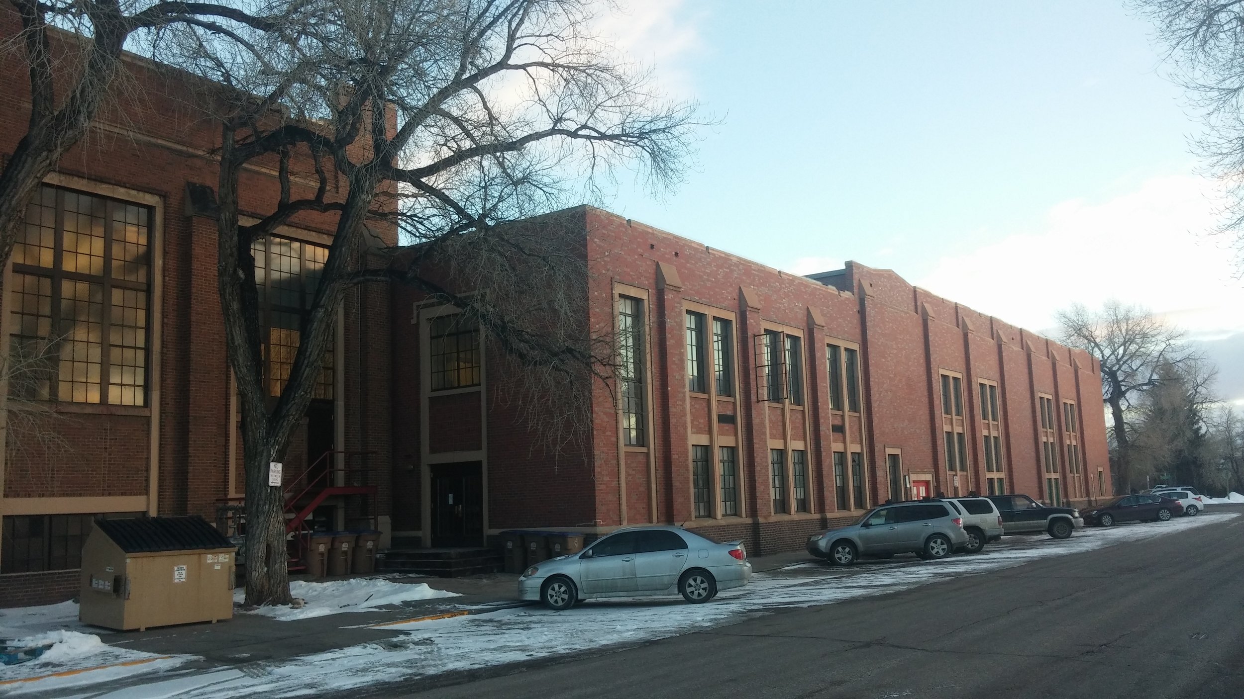 The west facade of the former school shows where two of the large additions converge, with the newer addition to the right and the older addition to the left.