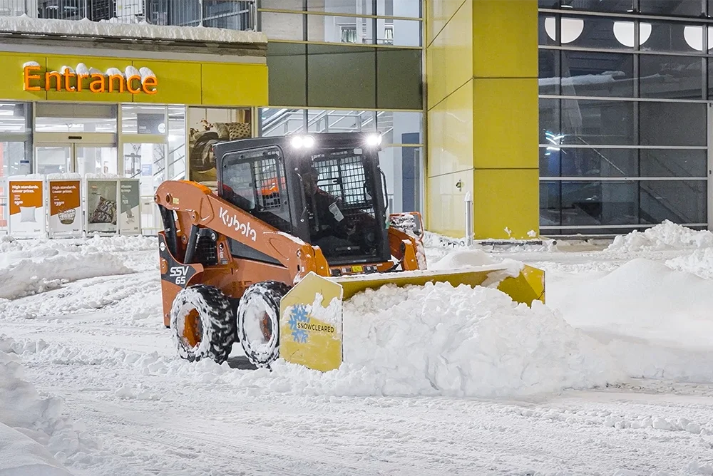 Snowcleared skid steer removing snow from a parking lot