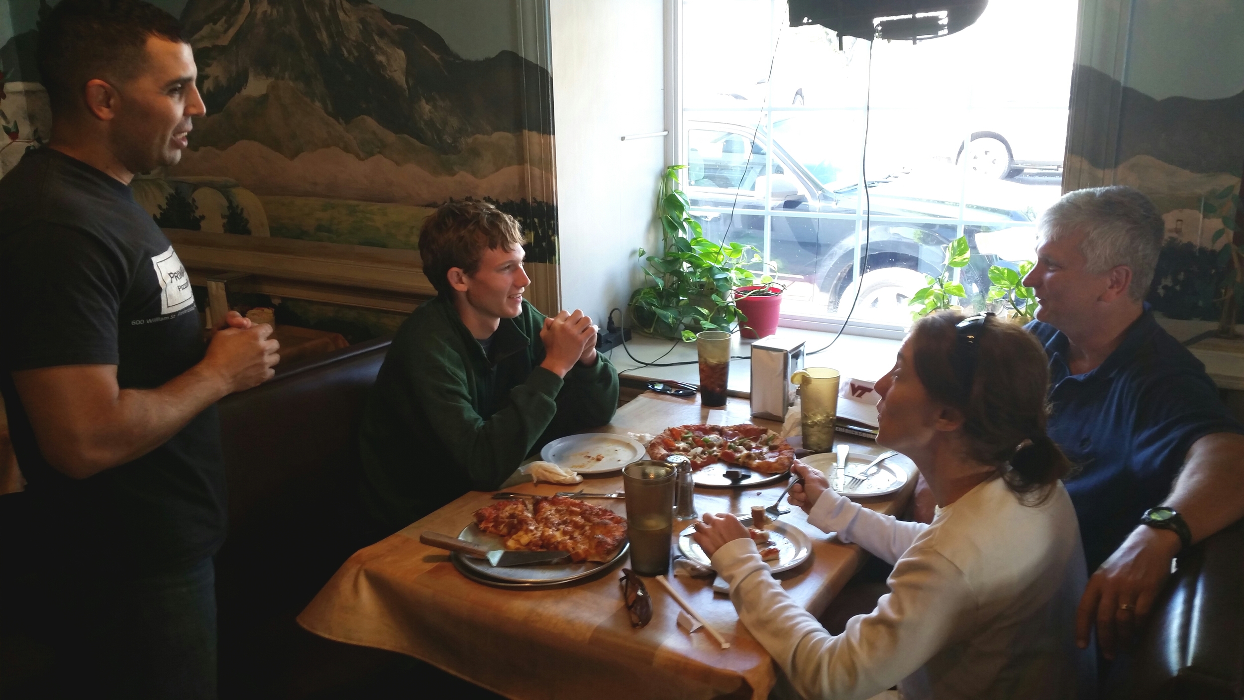 Photo by A.E. Bayne - Rami Hamrouni checks on the Platt family as they enjoy their first Primavera pizza.