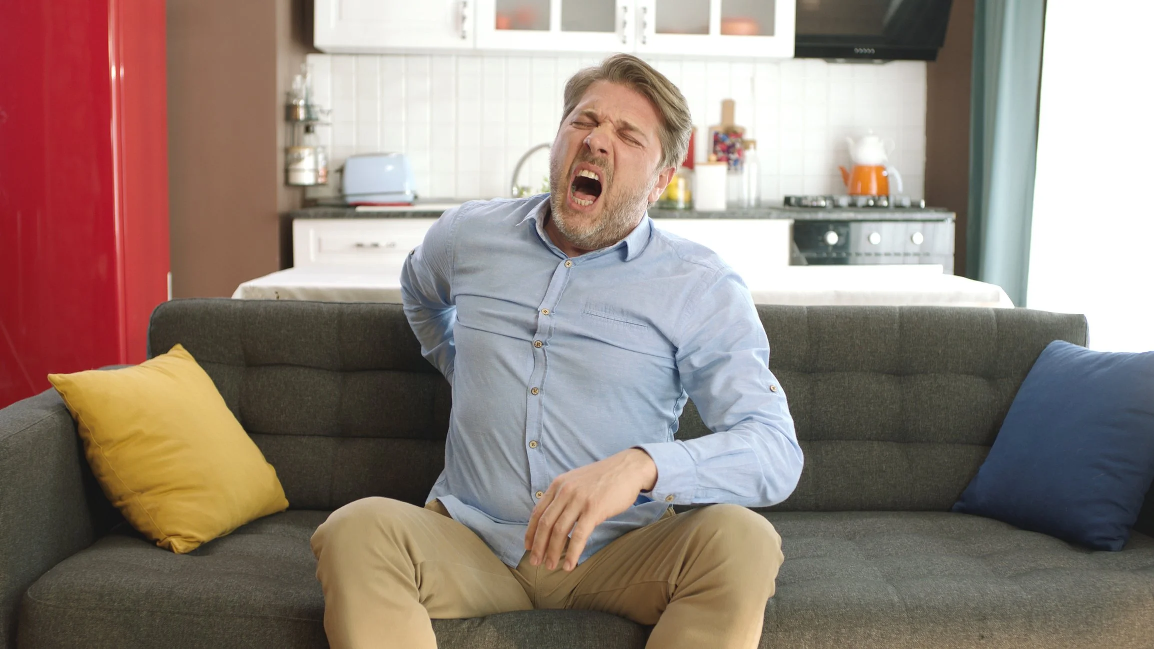 Funny man on couch with back pain.jpg