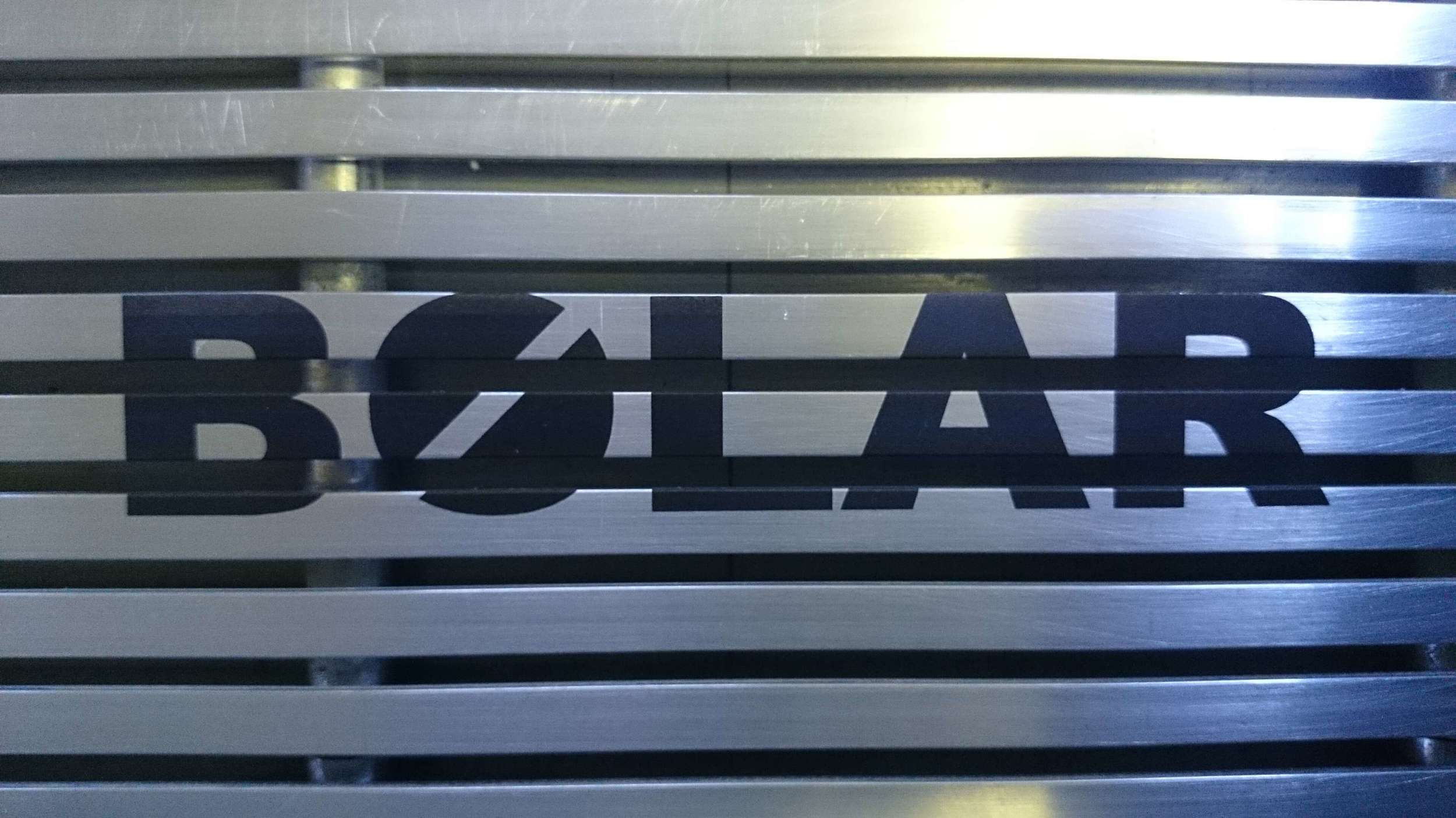 Grille de métal sur laquelle a été marquée au laser le logo de Bolar