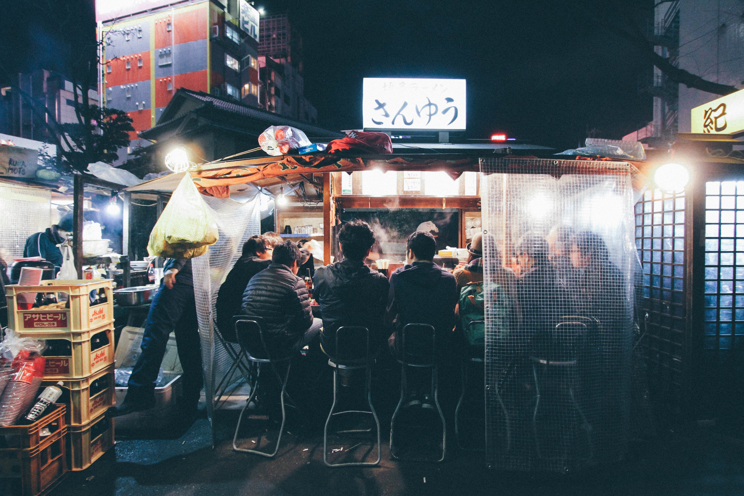 YATAI FUKUOKA, JAPAN "Yatai" are what they call food stalls in Japan and Fukuoka is famous for a row of them right by the river. These food stalls exemplify Japanese culture in such an accurate way. People sit an inch from strangers, enjoying some of the worlds best food, smoking their cigarettes, drinking cool beer, and watching the night pass by with quick witted conversation about the morals of life and business. ahh...Japan. 