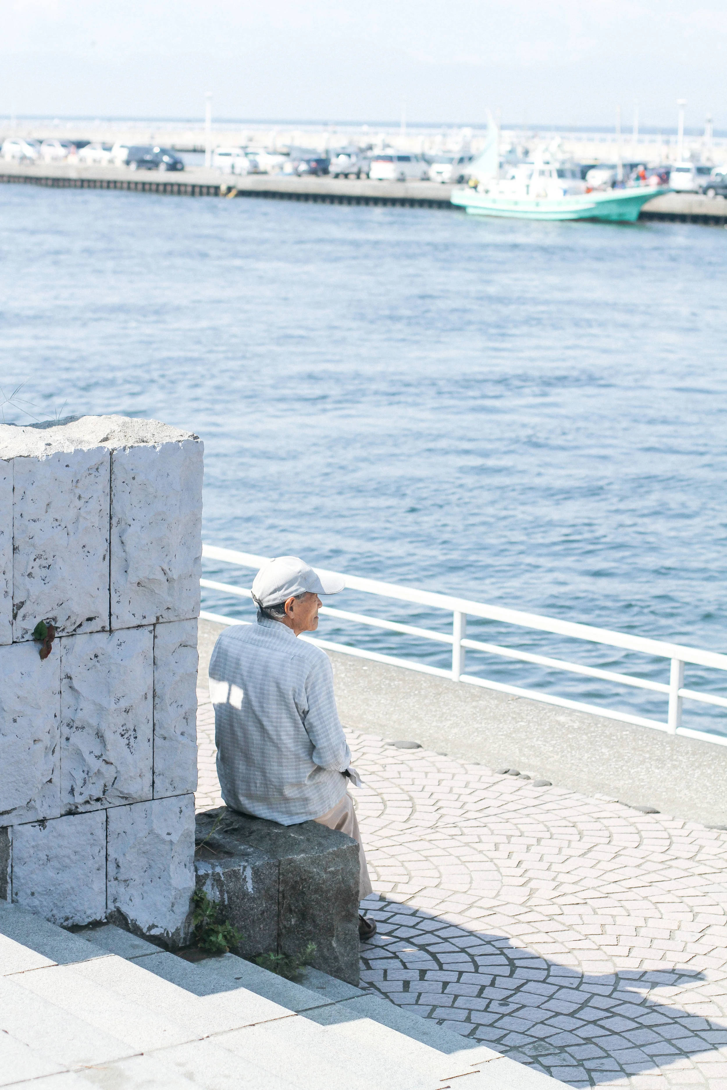 OLD MAN AND THE SEA ENOSHIMA- ENOSHIMA, KANAGAWA. I went to Enoshima with my two good friends, Steph and Ayaka, and as soon as my eyes met the ocean I felt at home. I love the water. Always have, always will. We were walking to the main shrine and I stopped dead in my tracks when I saw this man. He was sitting there, the most peaceful I have ever seen anyone, and he was simply gazing out into the sea. I imagined he was a fisherman in his youth, or grew up on the coast of Japan, so his memories are soaked in salt water and sea breeze. This is one of those pics that will forever be my favorite...the timing, the framing, the colors...nothing in which I did on my own...everything which was meant to be. 