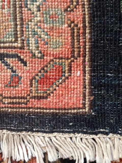 Reverse side of a hand-knotted carpet. Note imperfections in knotting, clarity of the rug design, and fringe as part of the rug construction.