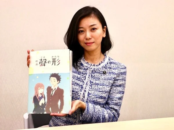MP Eri Saito, with a copy of the manga version of A Silent Voice.