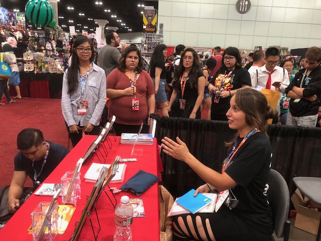 Signing books for fans at Anime Expo