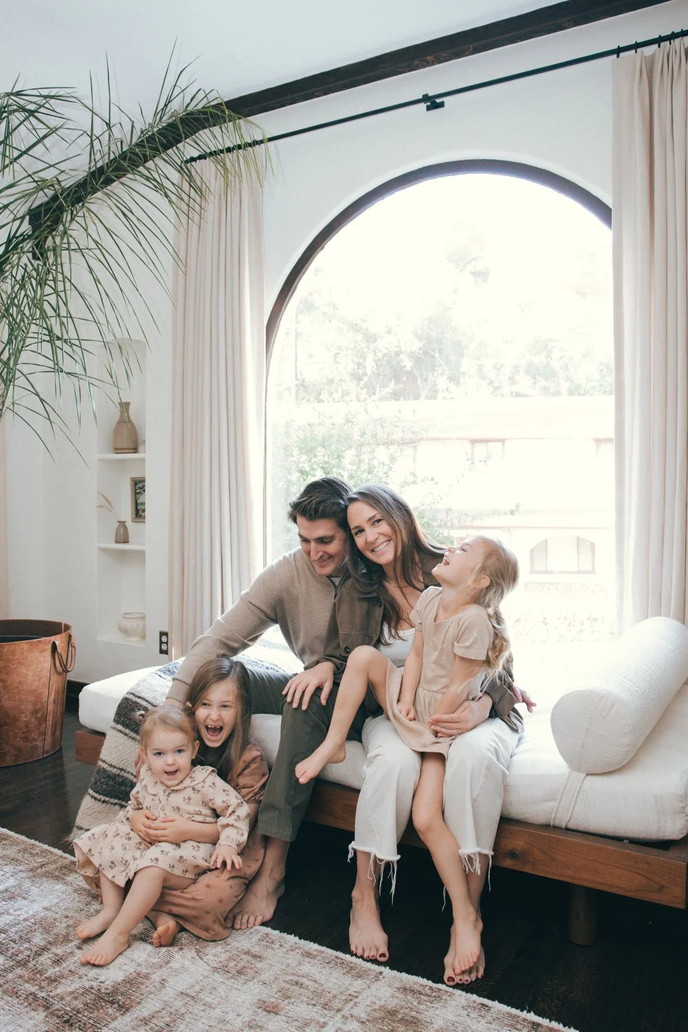 A happy family of five sitting on a couch in a bright, cozy living room. Los Angeles Family photographer. Santa Barbara family photographer. 