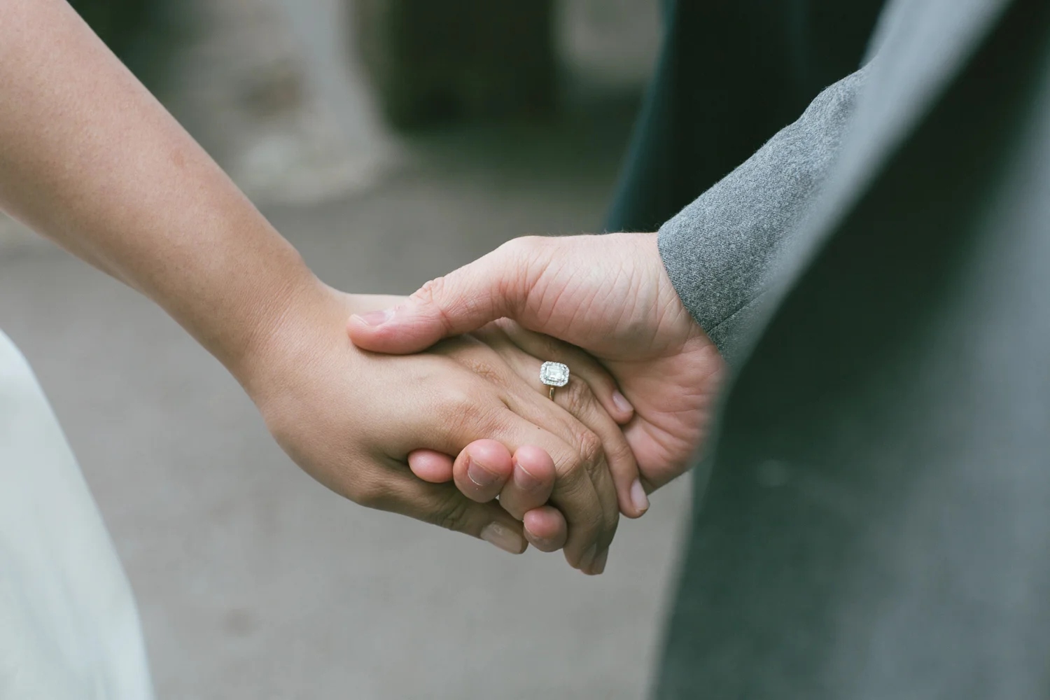 The bride and groom holding hands and showing off the bride's ring