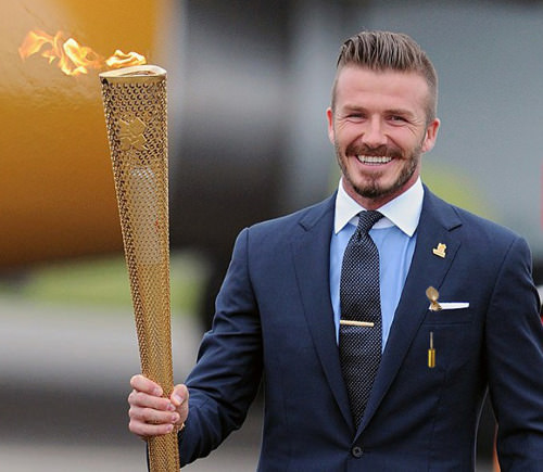 Aside from holding a big, flaming torch...notice how the contrast collar, the light blue shirt and the lapel pins all work to move the eye upward towards the face.