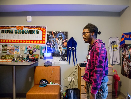 Anthony Anderson, 22, was homeless for three years and eight months. Now he is one of 38 young adults who have moved into apartments at the 66 West complex in Edina. http://www.startribune.com/once-homeless-young-adults-settle-in-at-new-apartment-complex-in-edina/439109263/ Dozens of posters, toys and trinkets adorn Anthony Anderson's new studio apartment in Edina. Several of the items were given to him during his stay at a Minneapolis shelter. Anderson, now 22, kept track of how long he was homeless: three years and eight months. "Most of this is just donated stuff given to me," he said. "Whatever a person gives me, I don't complain, I just take it." One item does hold special meaning — a necklace with a small cross, hanging from the wall behind his bed. "That's the last thing I have from my grandmother," he said. "I always have it hanging above me, just to help me sleep." Anderson is one of 38 young adults living at 66 West Apartments, a housing complex for young people who have been homeless. Beacon Interfaith Housing Collaborative, the developer, held a grand opening last week for the $11.4 million complex. Danae Gilbert spoke to patrons during the grand opening celebration for the 66 West Apartments in Edina. “I didn’t have to worry about things anymore as far as being stable,” she said. It's the third project of its kind that Beacon has developed and is its first in the suburbs. The nonprofit group opened a similar complex with 44 units in St. Paul last fall. The young tenants, most of them between ages 18 and 21, have personal yet all-too-similar stories. They come from dysfunctional families and have slept in shelters and foster homes and on couches; sometimes they had no place to spend the night at all. There are anywhere from 250 to 300 young people like them in the Twin Cities' west-metro suburbs, according to Beacon. But 66 West, located near Xerxes Avenue S. and W. 66th Street, is more than just beds. Residents have four full-time employees who guide them through school, work, community relationships and other life skills. The goal is for tenants to become stable enough to move within a couple of years to different housing, this time on their own terms. "It really opens up that hope, moving out of survival mode," said Lee Blons, executive director for Beacon. "This is that chance to get that support." The complex opened its doors in May, more than five years after the concept was first explored by Edina Community Lutheran Church. The church wanted to advocate for affordable, long-term housing for homeless young people until they realized that no such place existed in the west-metro suburbs. The church partnered with Beacon to develop the project and found support from neighboring congregations. Despite some pushback from businesses and neighbors, the Edina City Council approved the project in 2014. More than 70 percent of the project's cost was covered by the Minnesota Housing Finance Agency. Donors now fund 30 of the 39 units , allowing the tenants to pay subsidized rent, Blons said. Among other changes, residents must adjust to life in one of the metro area's most upscale suburbs. Sometimes that can feel overwhelming. "I'm just getting used to living by myself," said Lulu Mohamed, who moved in a day before her 17th birthday. "I'm not a 'burbs girl." Hardcover books line the window sill next to her bed. She works at a nearby Chipotle restaurant and hopes to start her senior year this fall at Minneapolis Washburn High School. Resident: 'I felt saved' On Thursday, hundreds gathered for the opening celebration. One by one, small groups took tours of the complex and the single unit still unoccupied. The building has a community space on the first floor, a gym in the basement and a computer lab. Studio apartments have brand-new appliances and furniture, including a table, a dresser and a bed. Project developers and elected officials addressed the crowd under a tent outside. So did Danae Gilbert, a 19-year-old who now calls 66 West home. Gilbert was born in Minneapolis and bounced around the Twin Cities as a child. Her ever-changing commute made it difficult to get to school or work. She applied to 66 West with the help of a youth advocacy center and was the first tenant to get approved. "I felt saved, in a way," she said. "I didn't have to worry about things anymore as far as being stable." She will soon start work at a nursing home as a dietary aide, and she hopes to complete her high school credits. During her speech, she thanked those involved in making 66 West a reality. "I will no longer have to struggle, and if I did, it'd be a choice," Gilbert told the crowd. "I refuse to make that choice, though, because I know you guys believe in me."