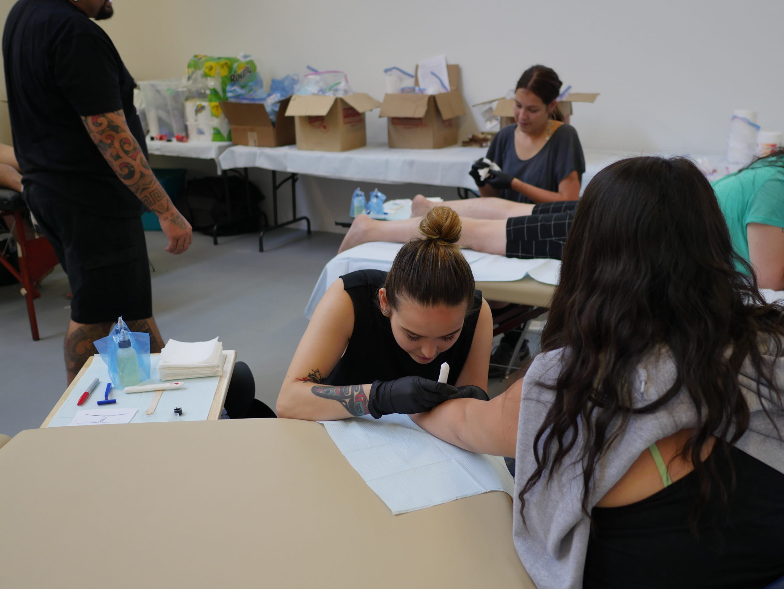 Female tattoo artists are Danika Nacaarella (forefront) and Maannii Oakes (background) .