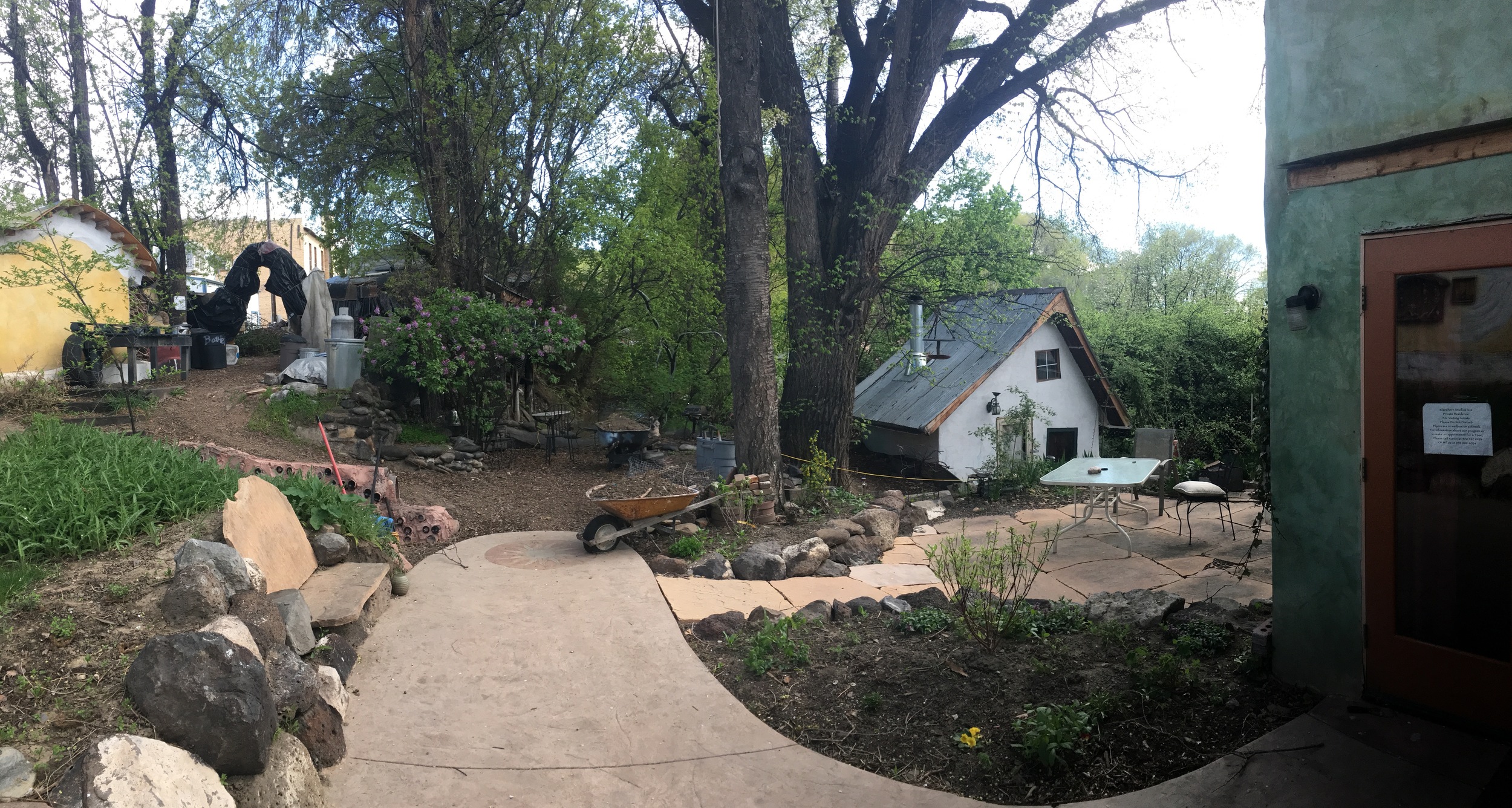 Wrap around view of path, gingerbread house (white) and main house (green)