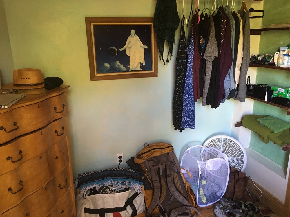 Under my loft bed: dresser and clothes rack (and picture of Jesus in space?)